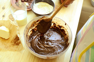 Woman preparing dough for chocolate pie on table close up