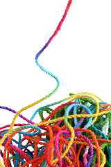 Tangled colorful sewing threads on white background.