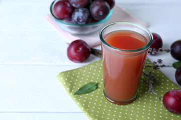 Delicious plum juice with fruits on wooden table close up