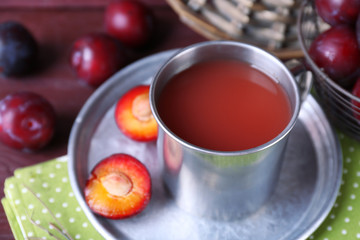 Delicious plum juice with fruits on table close up
