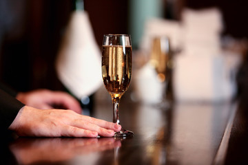 Bartender holding glass with champagne, close-up