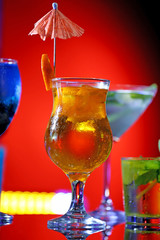 Glasses of cocktails on bar background