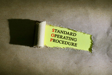 Torn paper with word standard operating procedure