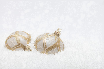 Gold and white baubles in fake snow