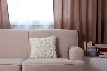 Comfortable sofa with pillows in the room, close up