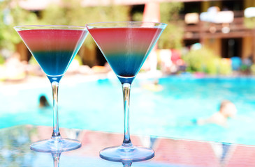 Cocktails on swimming pool background