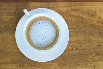 Cappuccino in white cup on wood background