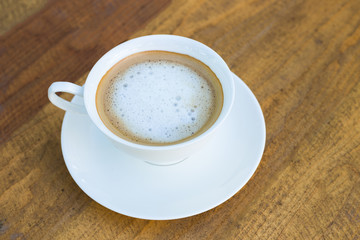 Cappuccino in white cup on wood background