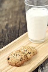 Almond cookies with milk on wood plate
