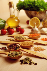 Variety of spices in spoons on the kitchen table