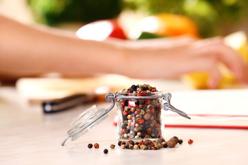 Mix pepper spices in the glass jar on kitchen table