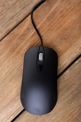 Computer mouse with cord on wooden background