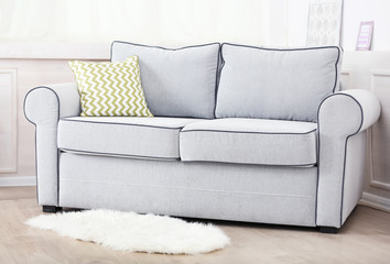 Gray sofa with colorful pillows in room