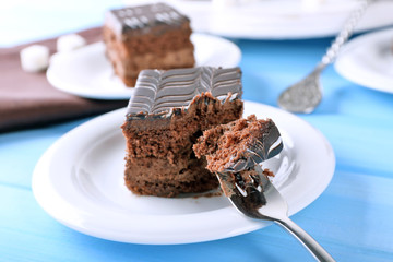 Served table with chocolate cake on blue background close-up