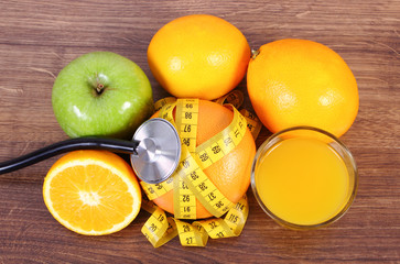 Stethoscope, fresh fruits, juice and centimeter, healthy lifestyles and nutrition