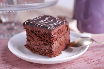 Served table with a cup of tea and chocolate cake on wooden background close-up