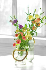 Fototapeta na wymiar Beautiful spring flowers in vase on window background