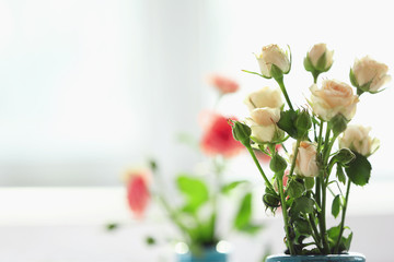 Beautiful spring flowers in vase on window background