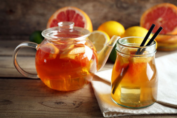 Iced tea with lemon and grapefruit on wooden background