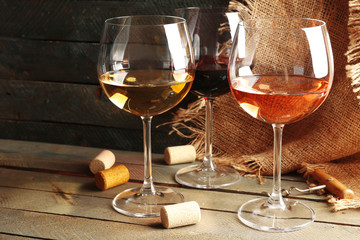 Composition of wine glasses and corks on wooden background