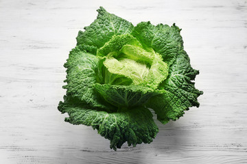 Savoy cabbage on light wooden background