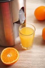Juicer and orange juice on kitchen table