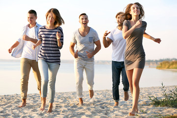 Obraz premium Young people with beer on the riverside