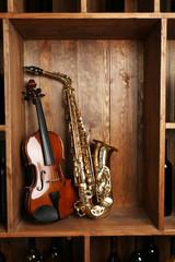 Naklejka premium Musical instruments: saxophone, violin on wooden background