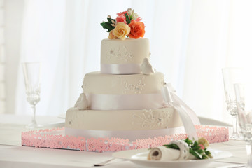 Wedding layered cake in decorated restaurant on window  background