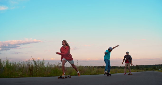 Friends are practicing their longboard skills on empty road