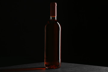 Fototapeta na wymiar A bottle of wine, on grey-black background