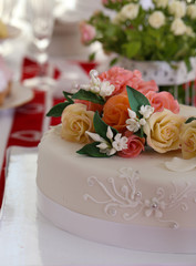White wedding cake with flowers on the table, close-up
