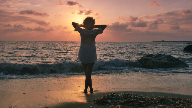 a woman enjoying a holiday by the sea at sunset 