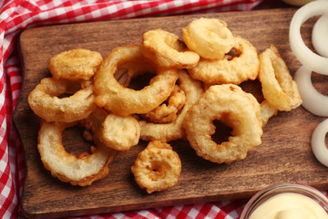 Chips rings with sauce and onion on cutting board