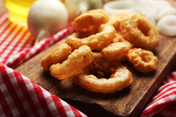 Chips rings with sauce and onion on cutting board