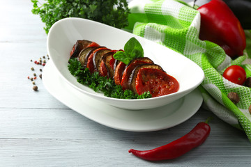 Ratatouille in bowl, on wooden table background