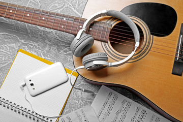 Fototapeta na wymiar Classical guitar and headphones with phone on grey background