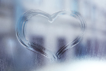 Fototapeta na wymiar Heart drawn on the fogged glass window