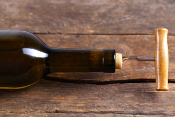 Obraz na płótnie Canvas Bottle of wine with corkscrew on wooden background