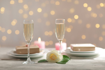 Glasses of wine and a white rose, on blurred background