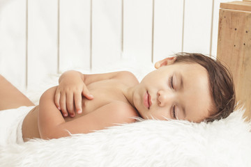 Obraz na płótnie Canvas handsome cute toddler sleeping on fur blanket