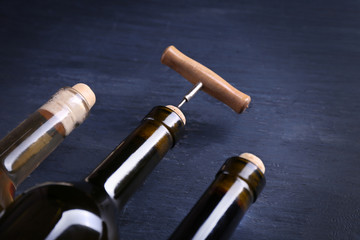 Obraz na płótnie Canvas Three bottle wine and corkscrew on blue wooden background