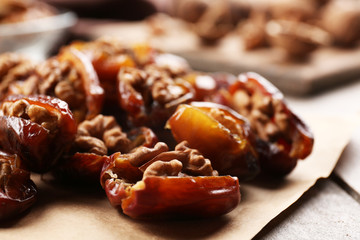 Walnut and date fruit on wooden table, close-up