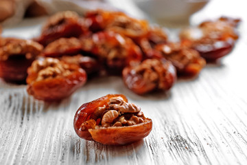 Walnut and date fruit on wooden table, close-up