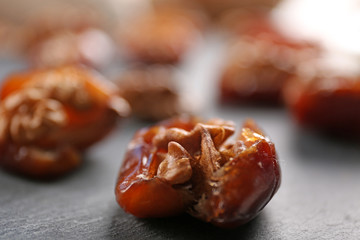 Walnut and date fruit on wooden table, close-up