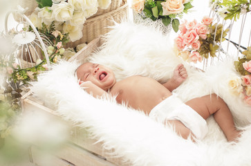 baby girl crying while lying in box with fur blanket