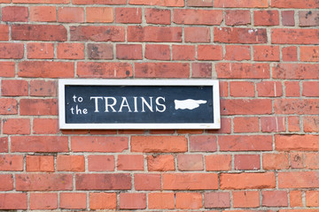 Fototapeta premium To The Trains sign on wall at Railway Station