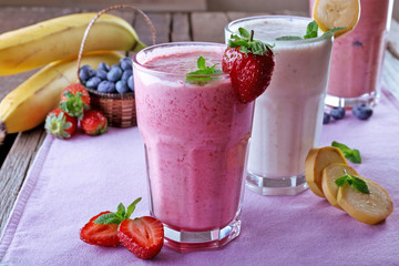 Glasses of fresh cold smoothie with fruit and berries, on the table, close-up