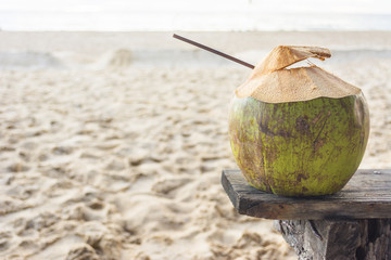 Fresh coconut water on The old wooden chair at beach in Phuket ,