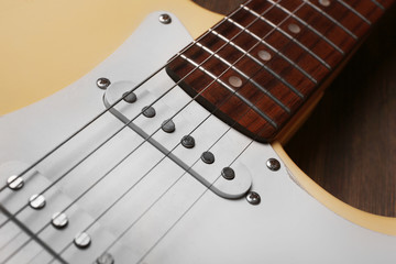 Electric guitar on wooden background, close up